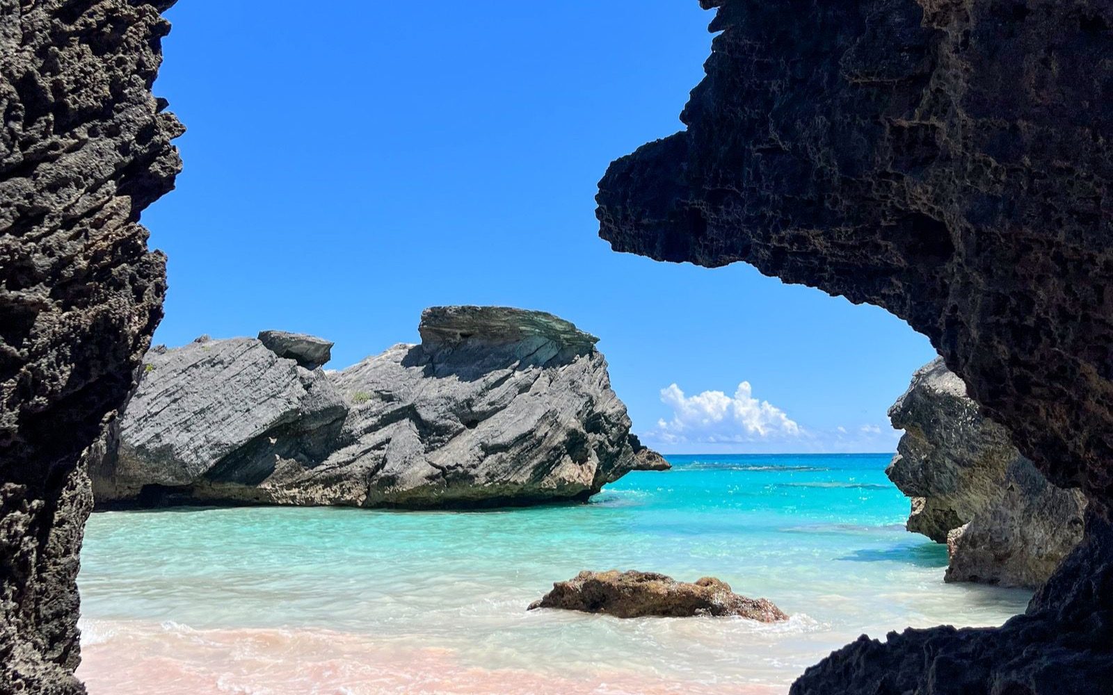 Pink sand framed by Bermuda's rock formations.