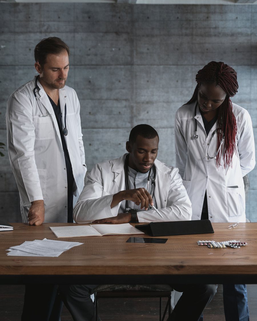 Three doctors reviewing a case together at a table
