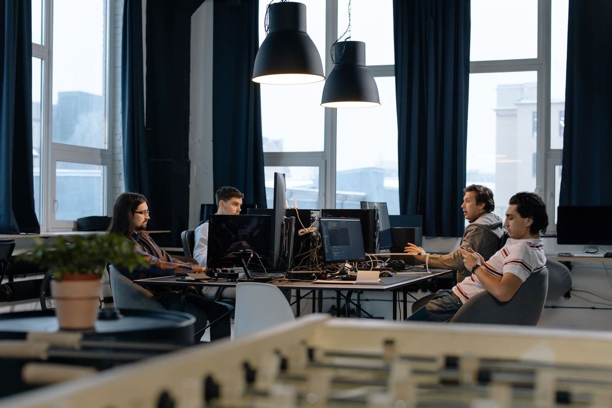 A technology team working together at computer screens in a modern office